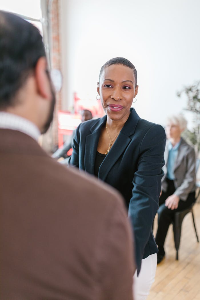 Businesswoman engaging in a professional handshake during a meeting, promoting teamwork.